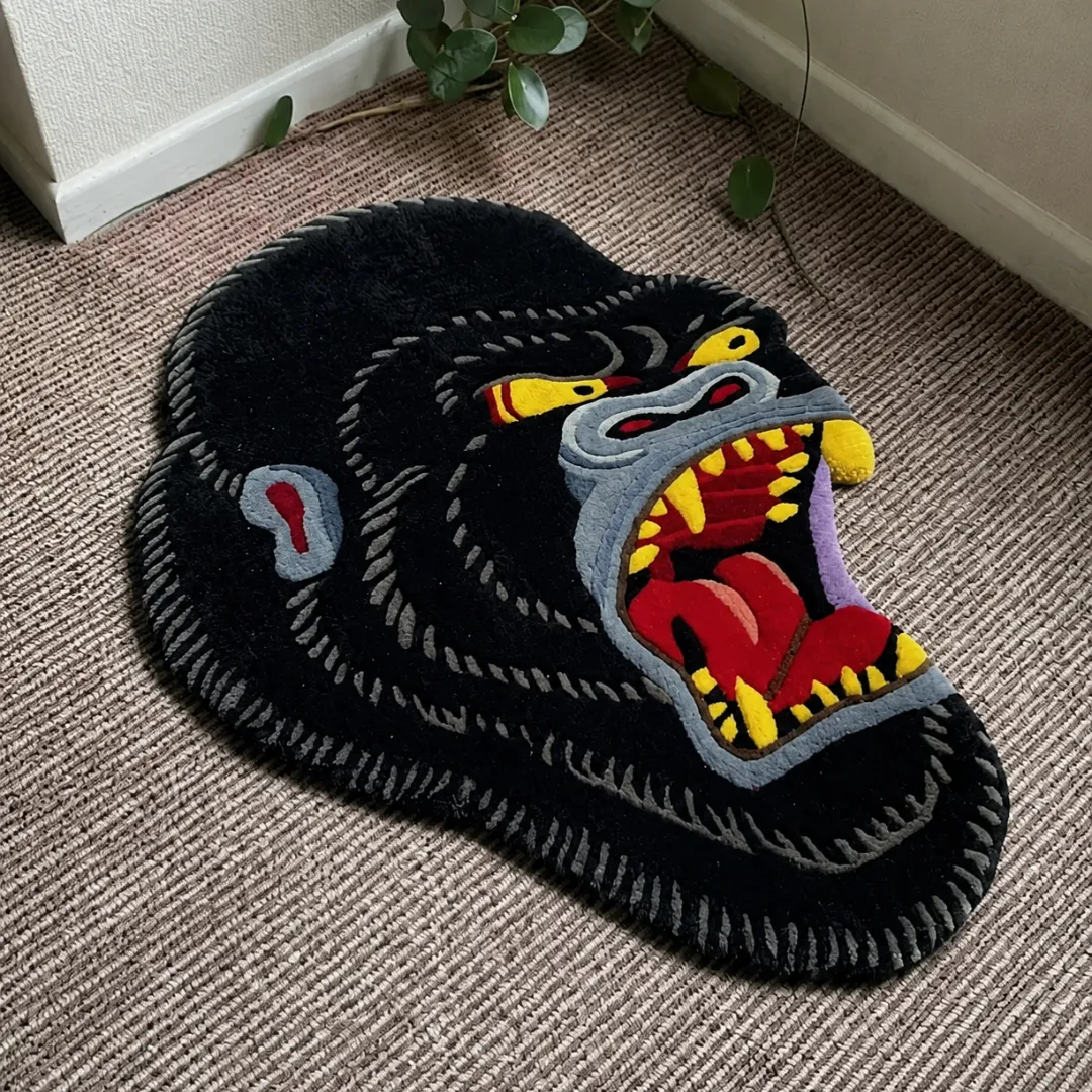Angle view of the handmade Gorilla Head tufted rug showcasing its unique organic contours and bold tattoo-inspired artwork on a carpeted floor.