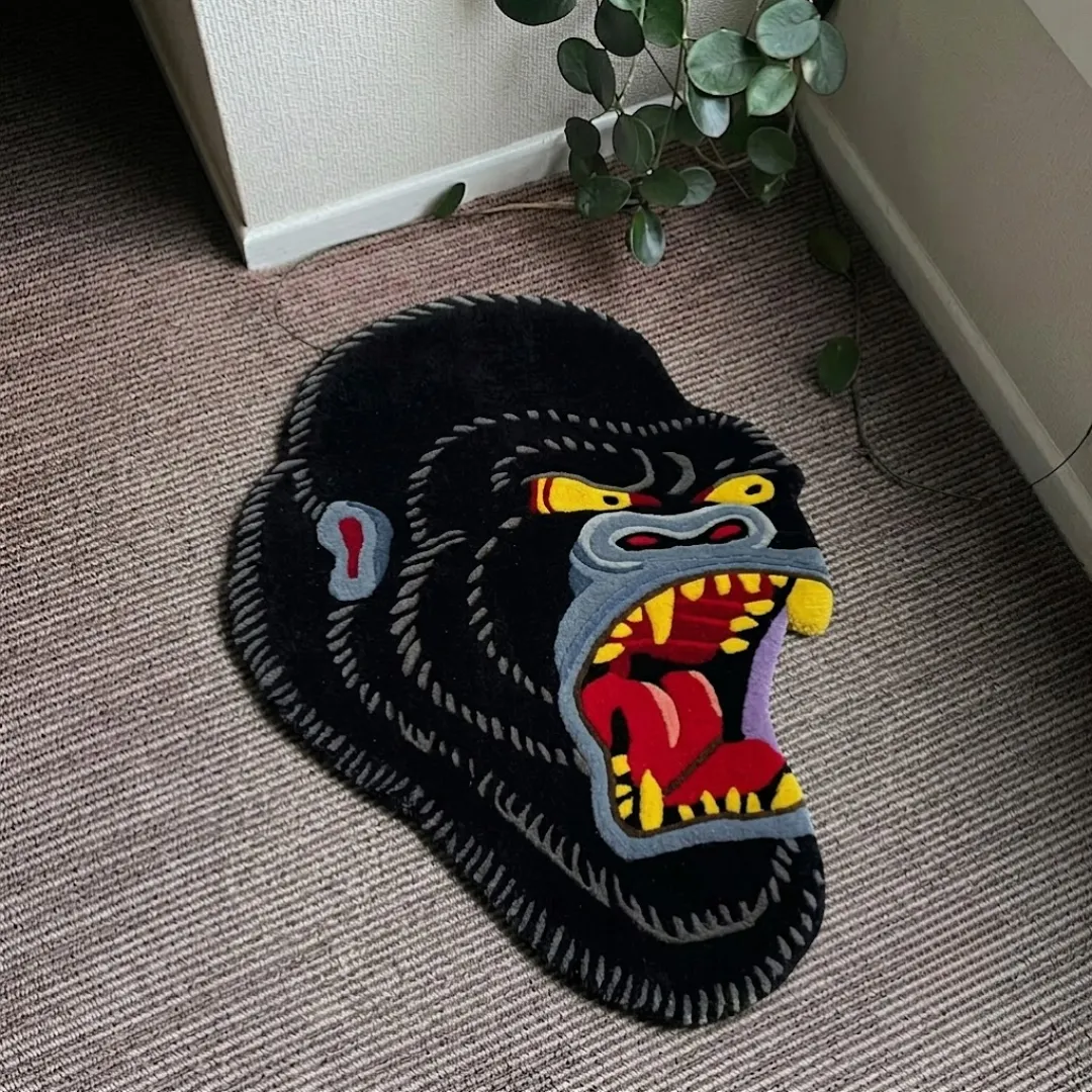 Gorilla Head traditional tattoo style angry gorilla shaped tufted area rug displayed flat on a textured carpeted floor.