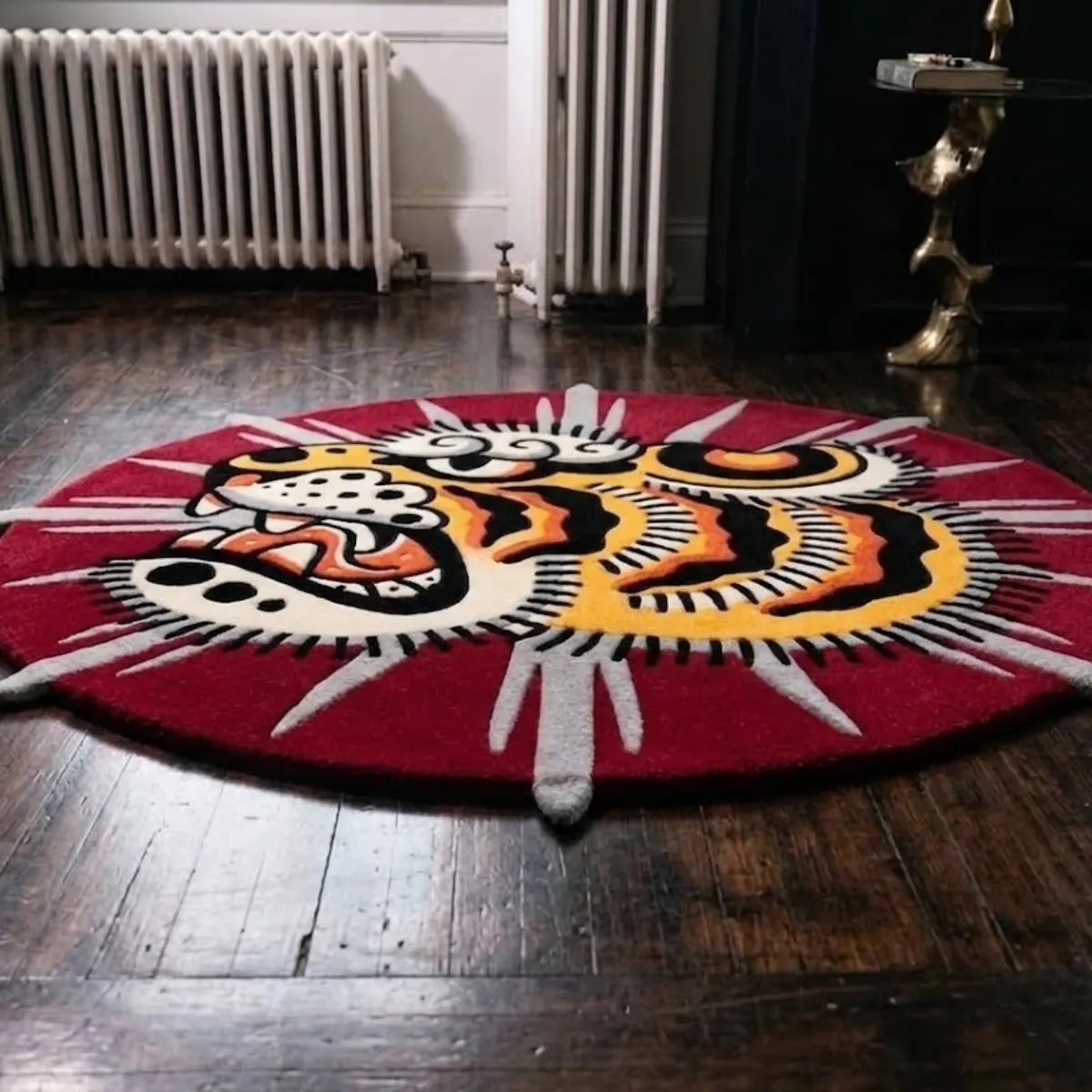 A low-angle view of the Sun Tiger rug placed on a dark wood floor. This highly detailed, 8k quality shot highlights the crisp color blocking of the traditional tattoo tiger design and the striking textured grey sun rays. The thick tufted yarn features internal stuffing for a luxurious, natural softness, perfectly capturing the bold, unshaded style of this custom-shaped statement piece.