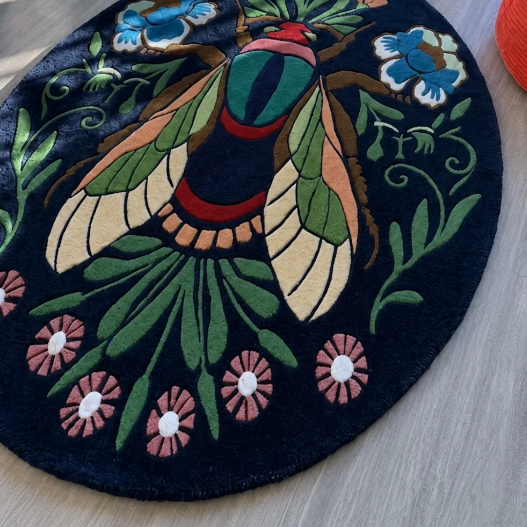 Angle view of the handmade Boho Butterfly Insect tufted rug showcasing its rich dark background and colorful nature-inspired patterns.