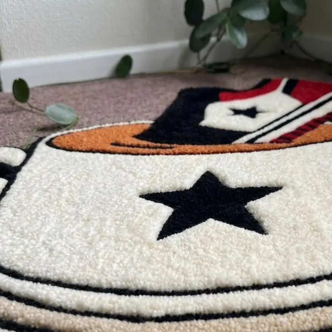 A macro close-up of the sneaker teacup rug, focusing on the dense tufted wool pile, carved black star emblem, and clean color blocking.