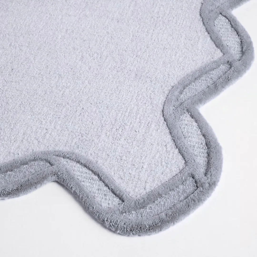 Top view of hand tufted gray and black area rug on wooden floor