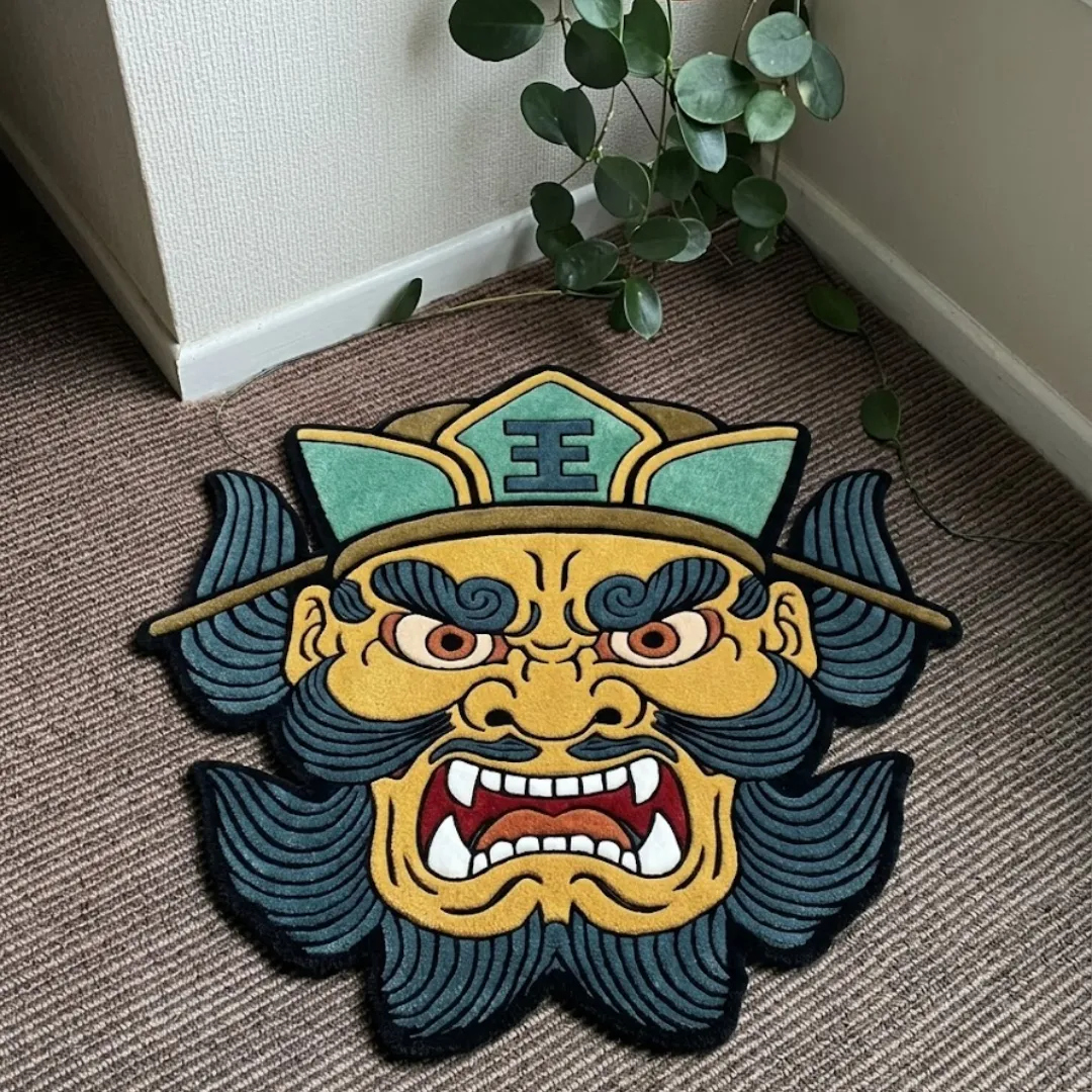 Wrath Samurai Mask shaped tufted area rug displayed flat on a textured carpet near a potted plant.