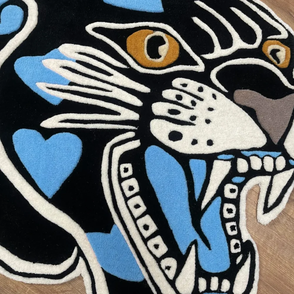 Custom-shaped panther head rug with black background and blue heart patterns, featuring fierce teeth and golden eyes in a tattoo-inspired design zoom in.