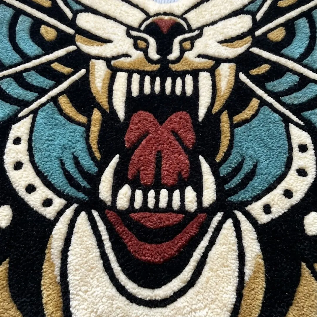 A macro close-up of the death moth roar rug, focusing on the dense, tufted wool pile and the intricate graphic design of the roaring creature face.