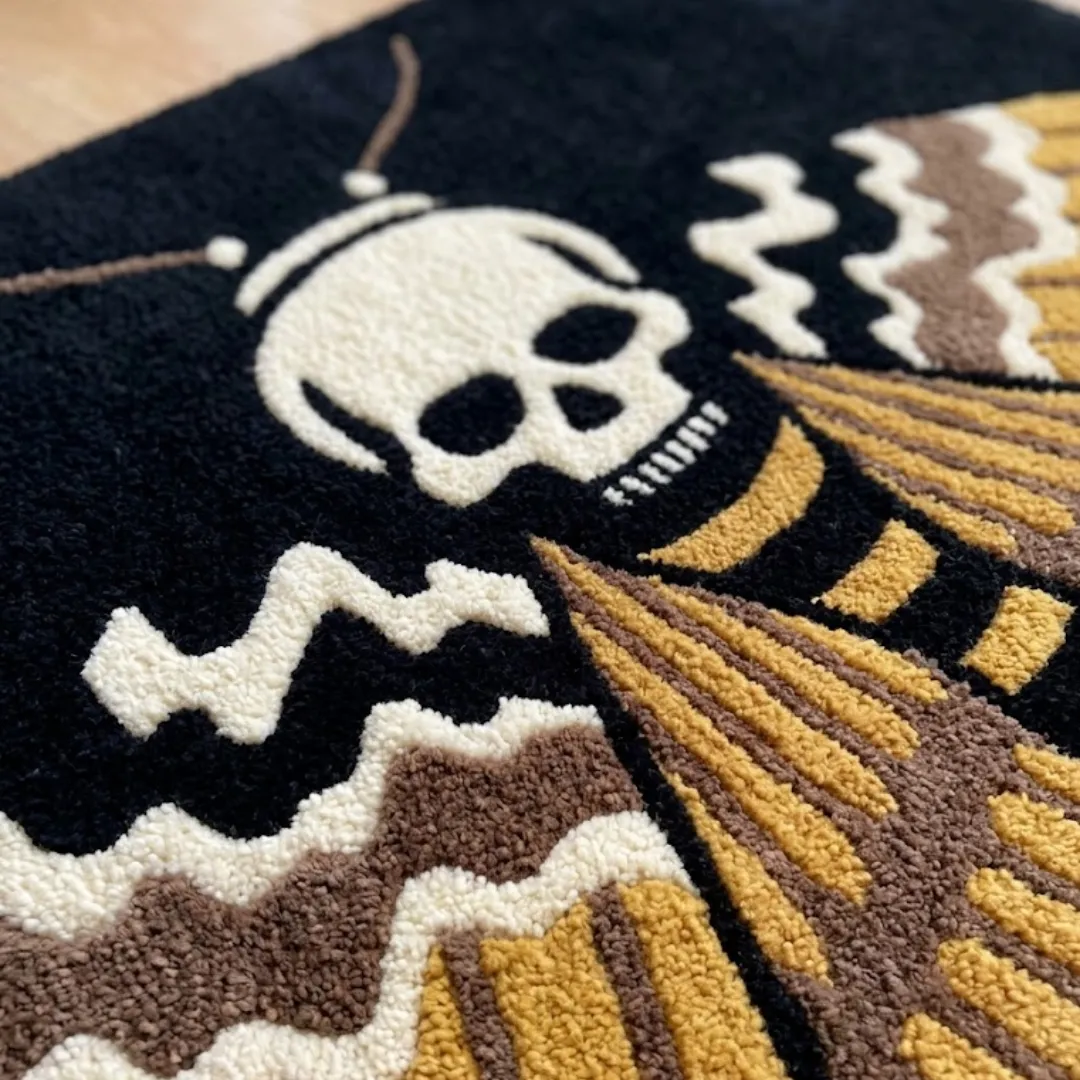 A detailed close-up of the skull moth rug, highlighting the dense, high-quality tufted wool texture and the bold, graphic lines of the gothic design.