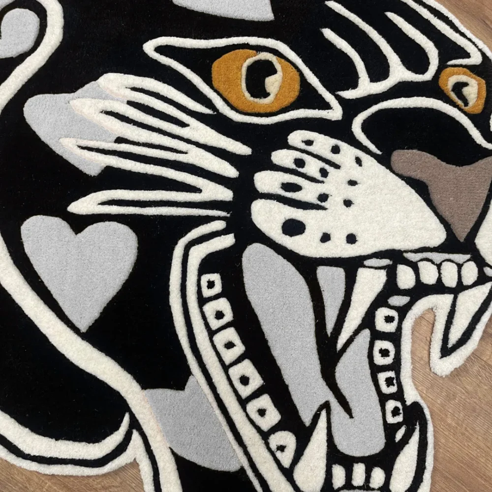 Custom-shaped panther head rug with black background and gray heart patterns, featuring fierce teeth and golden eyes in a tattoo-inspired design zoom in.
