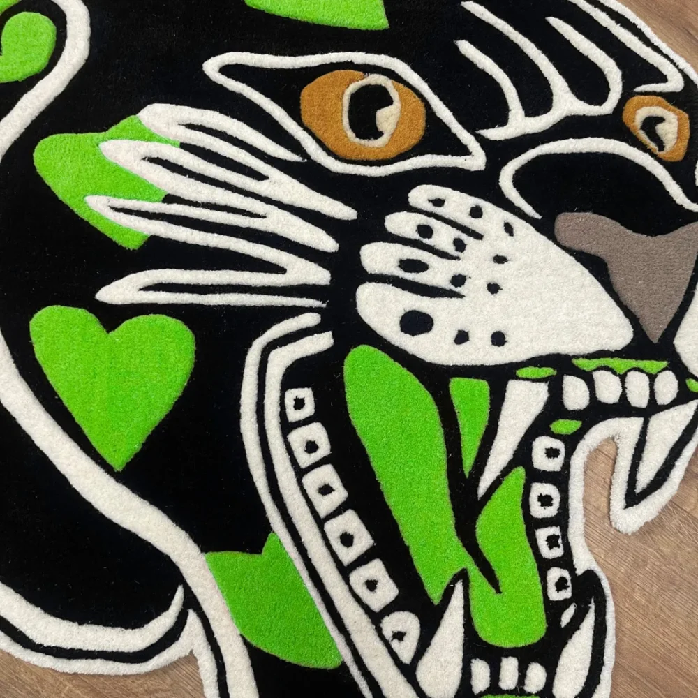 Custom-shaped panther head rug with black background and green heart patterns, featuring fierce teeth and golden eyes in a tattoo-inspired design zoom in.