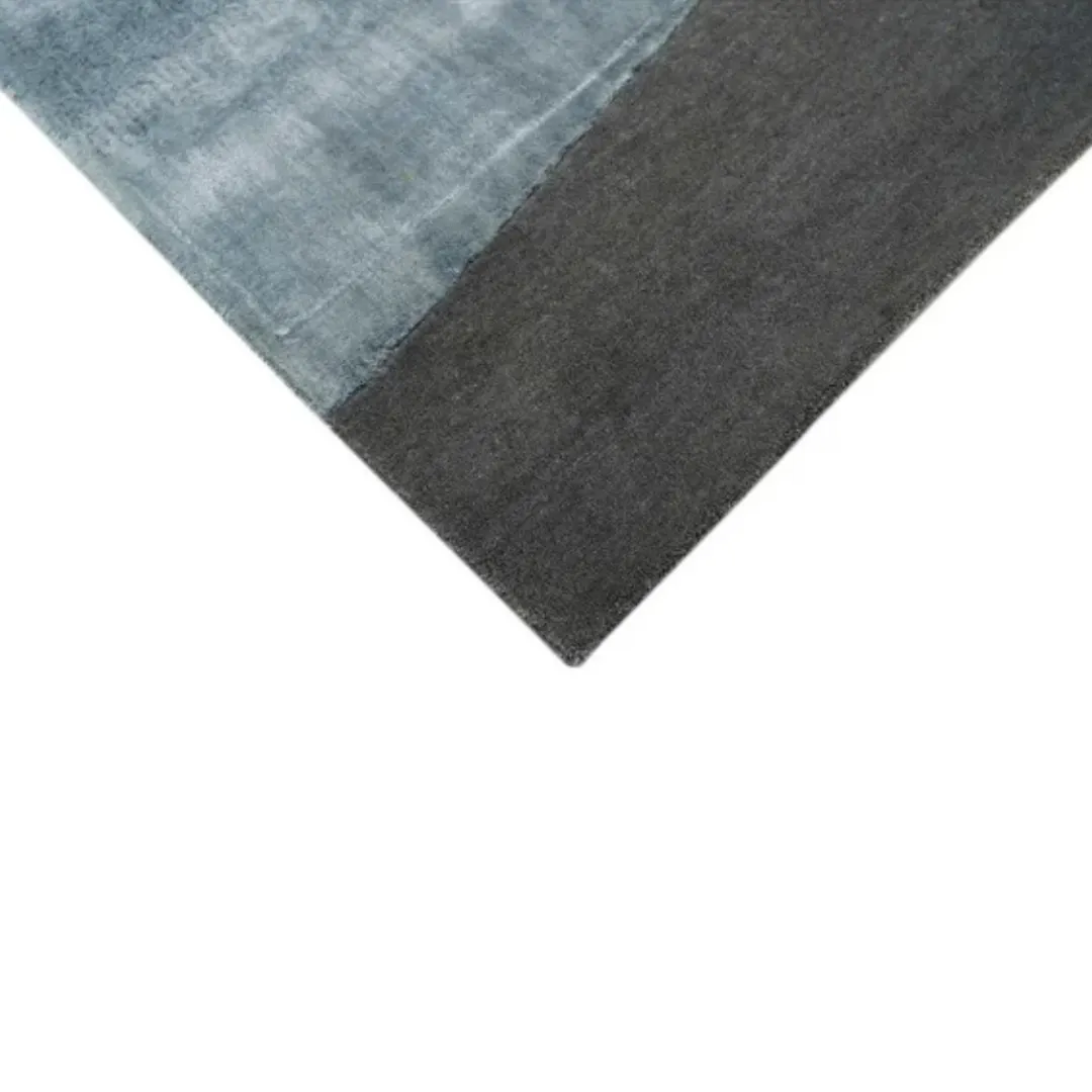 Abstract rectangular rug featuring deep blue and black color blocks with a soft finish.