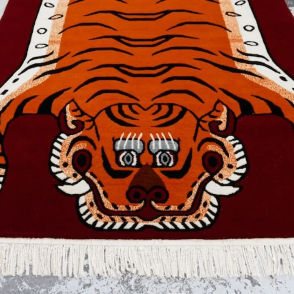 Orange wool tiger rug with traditional Tibetan design, believed to support focus during meditation.