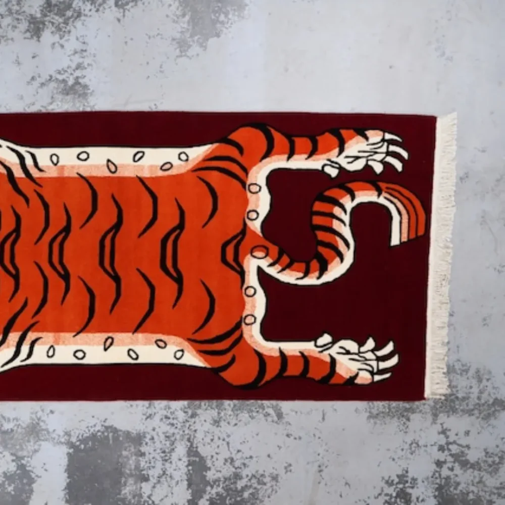 Tibetan-style tiger rug featuring bold stripes and deep red background, often used in spiritual practice.