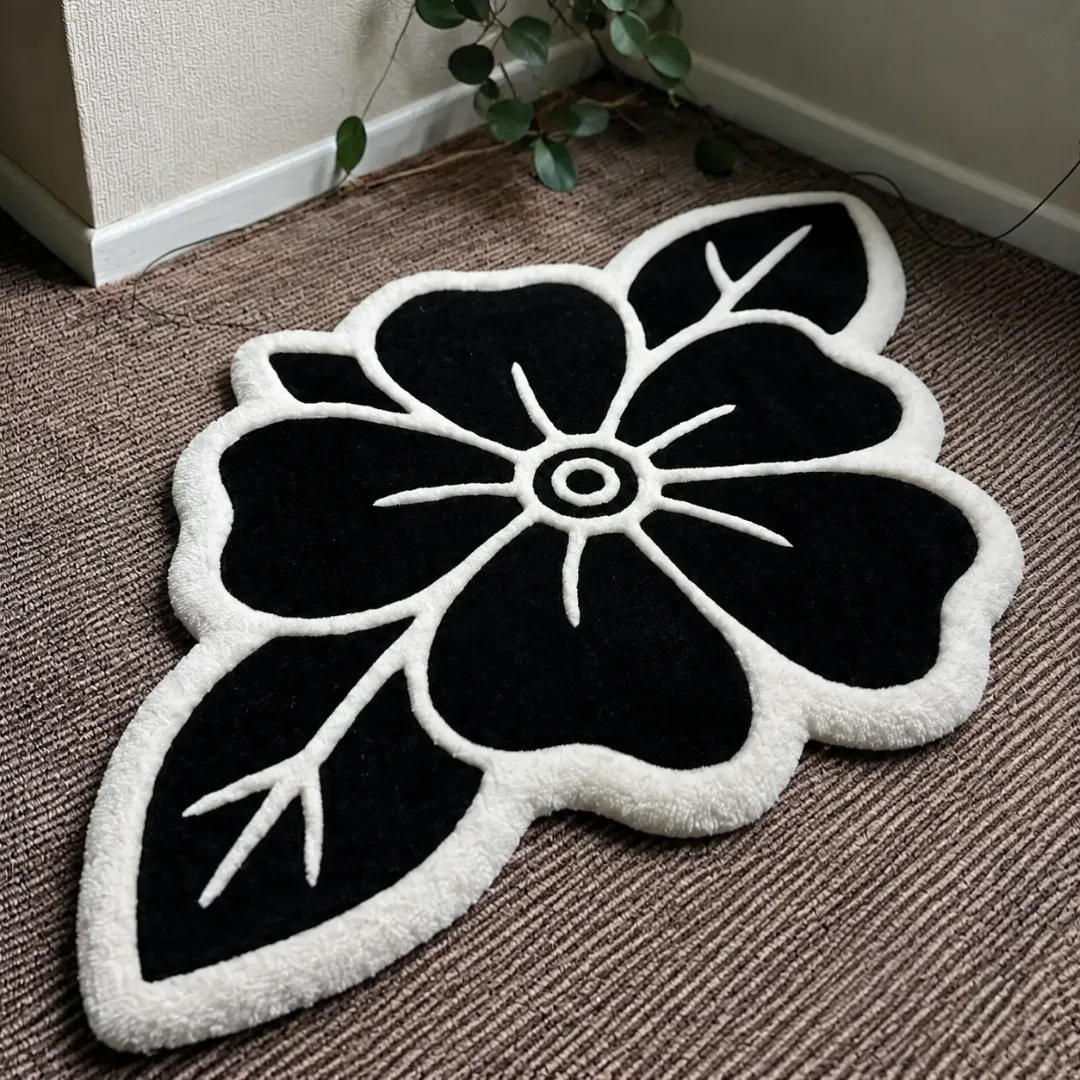 Close-up of the detailed tufted pile texture, striking black petals, and crisp white carved line details on the Blackwork Rose rug.
