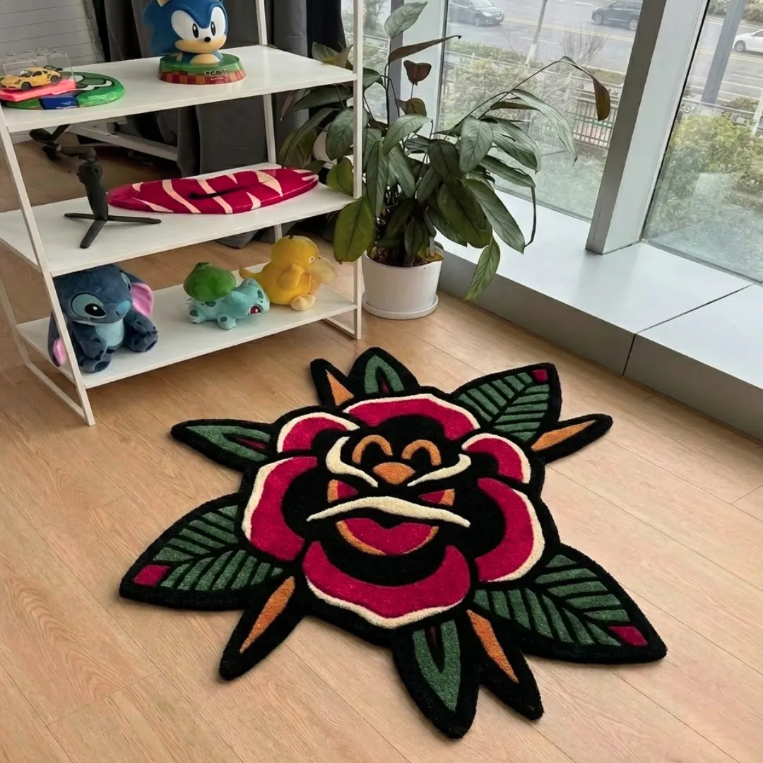 An interior view of a vibrant, traditional tattoo-style rose area rug placed on light wood flooring in a room with a white storage shelf featuring various character collectibles.