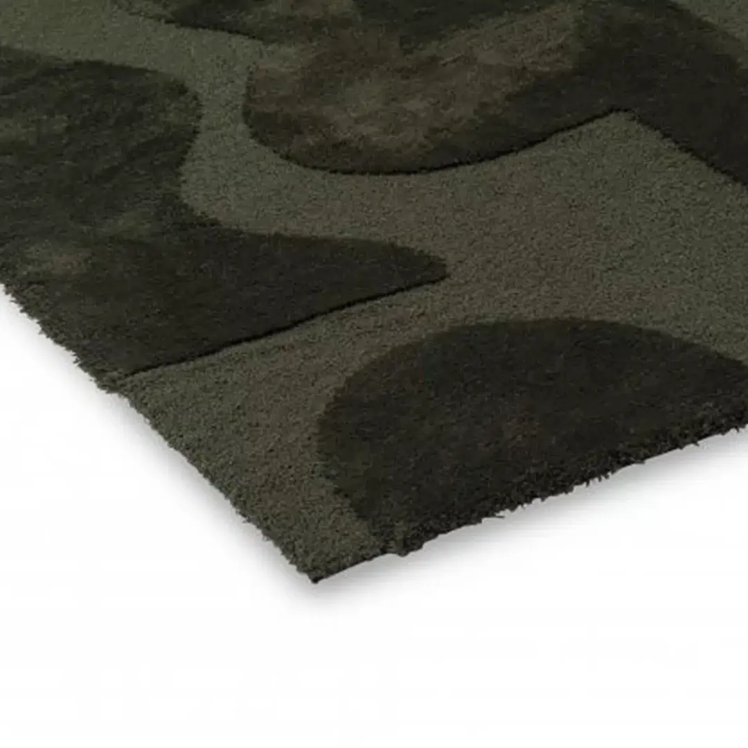 Abstract geometric rug with dark green face-like figures.