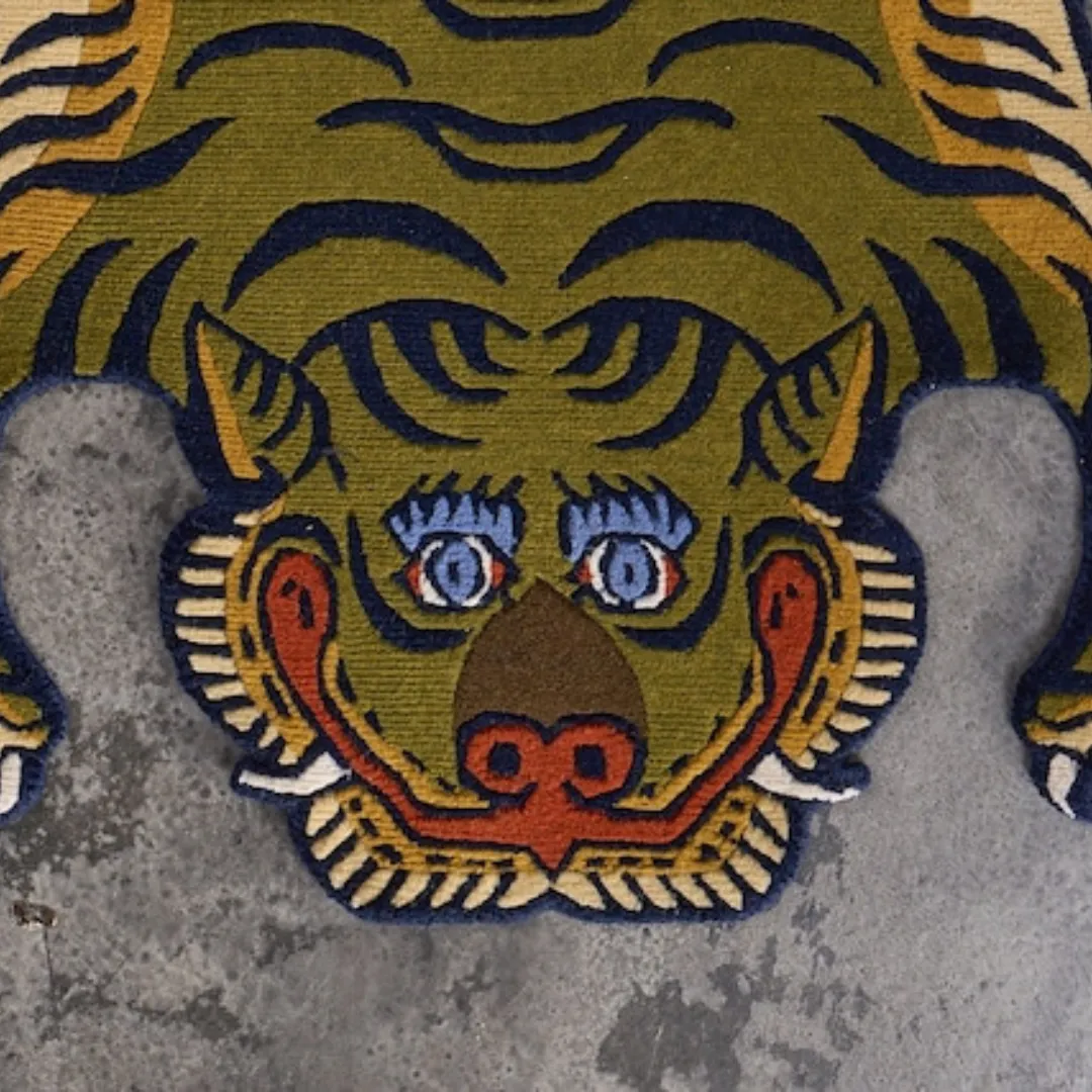 Close-up of detailed tiger design in green and yellow wool rug