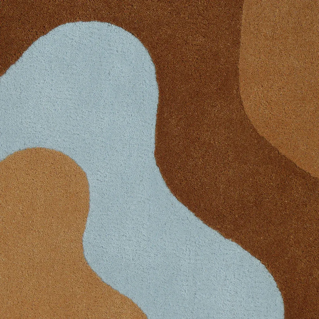 Ripple Rug Handmade brown rug with layered ripple shapes and soft blue center – Terra Ripple design