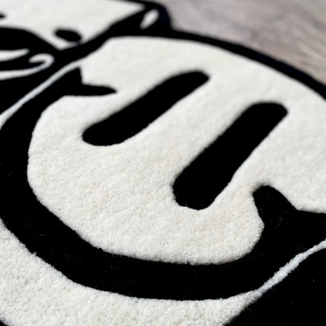 Bold monochrome Twin Reaper Rug with skull, smiley, and statue face art – hand-tufted modern rug