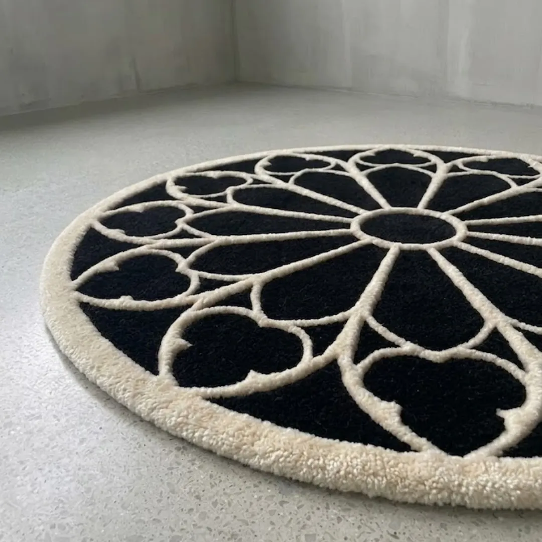 An angled close-up view of the round Eclipse Halo Rug on a smooth light floor. The image highlights the plush, high-quality tufted texture of the contrasting black and white yarn, showcasing the detailed geometric halo design.