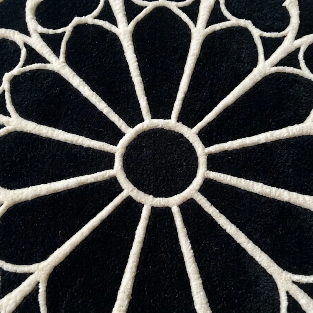 A detailed close-up of the center of the Eclipse Halo Rug. The image focuses on the thick, tufted white lines radiating symmetrically from a central black circle, emphasizing the crisp craftsmanship of the geometric pattern.