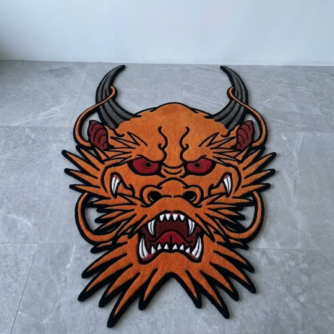 hellfire spirit japanese tattoo rug grey floor A top-down view of the hand-tufted Hellfire Spirit Rug resting on a light grey tiled floor against a clean white wall. The custom cut-out rug features a bold traditional Japanese tattoo design of a fierce orange dragon head with dark grey horns, striking red eyes, and an open roaring mouth displaying sharp white teeth, all defined by thick black outlines.