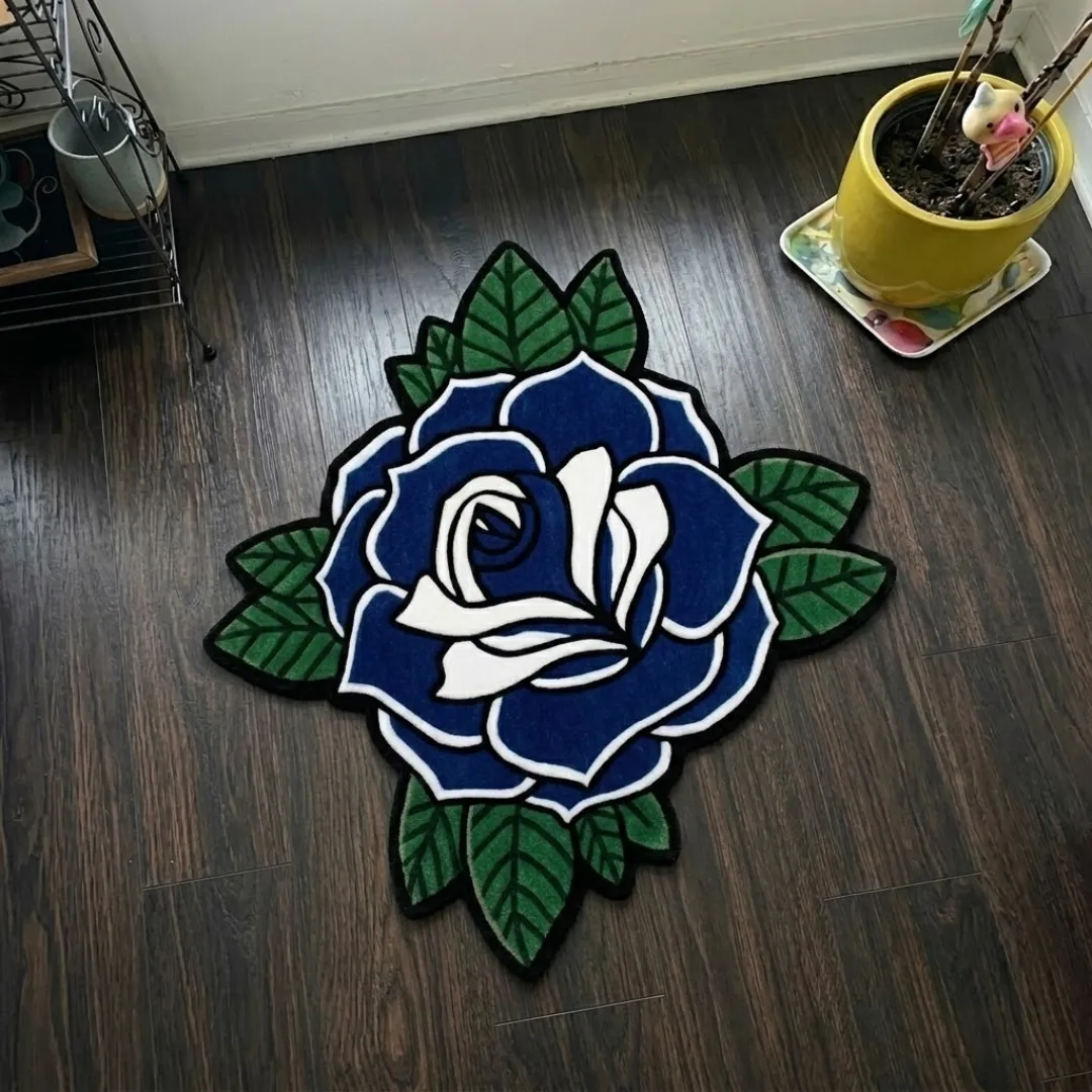luna rose rug top view Luna Rose traditional tattoo style blue rose shaped tufted area rug displayed flat on a dark wooden floor.