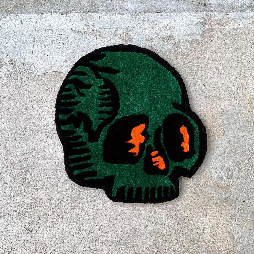 Verdant Skull Rug featuring green skull design with orange accents – handmade tattoo rug by Sneagear