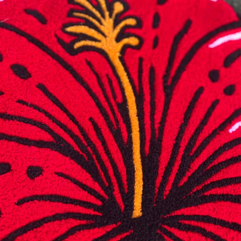 Close up texture detail of the Ember Petal rug showing the black outlining and yellow stamen on the red wool petals.