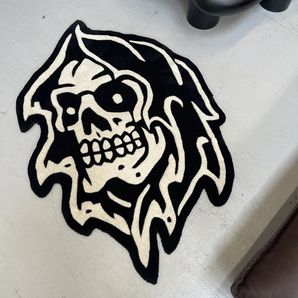 Top down view of the Grim Reaper rug featuring a classic American tattoo style skull design with a hooded cowl in bold black and white.