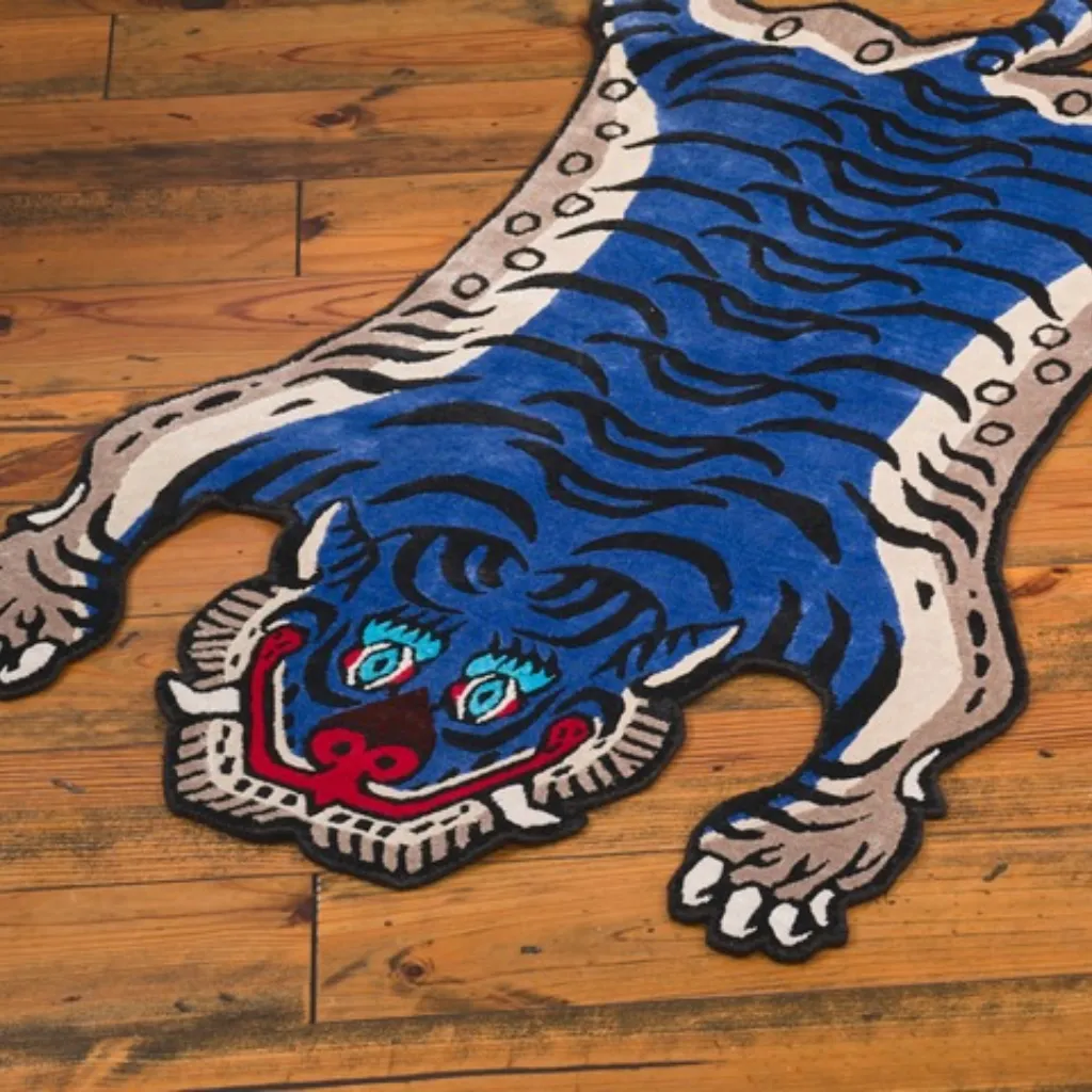 Angled view of the front section of the Cobalt Fang rug, highlighting the dense hand-tufted wool texture and the intricate blue and black stripe pattern inspired by Tibetan folk art.