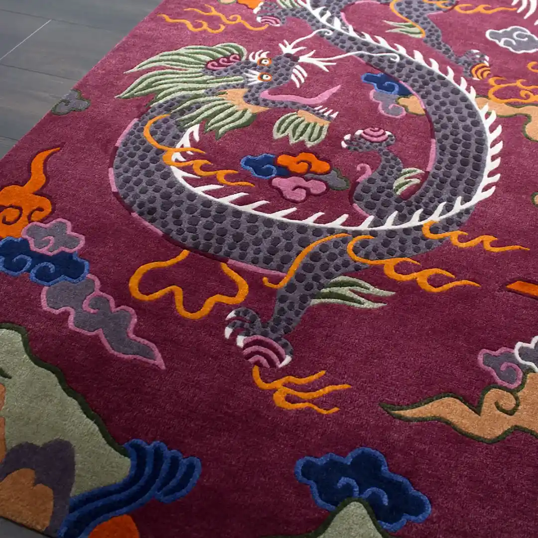 High angle shot of the Crimson Omen area rug placed on a dark wooden floor, showcasing the bold oriental design and the rich maroon color palette.