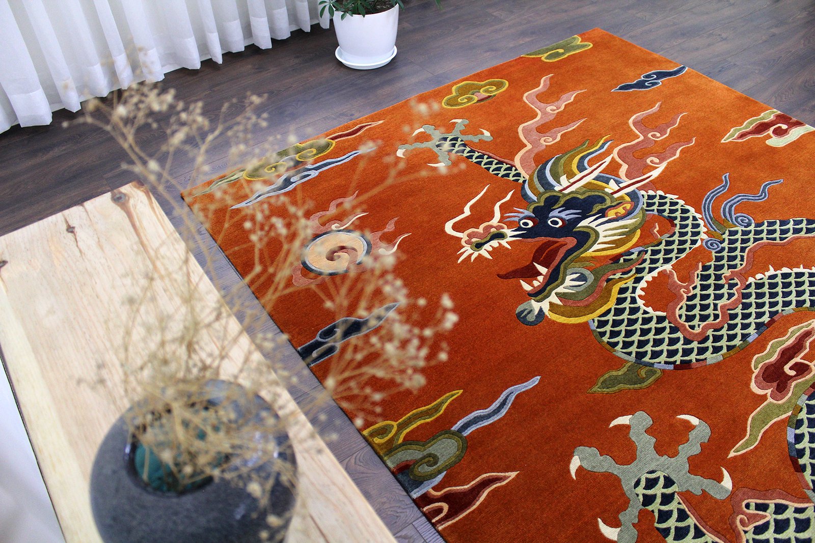 Side perspective view of the rectangular Ember Rise rug in a modern home setting, emphasizing the plush pile height and the vivid contrast of the blue dragon against the orange base.