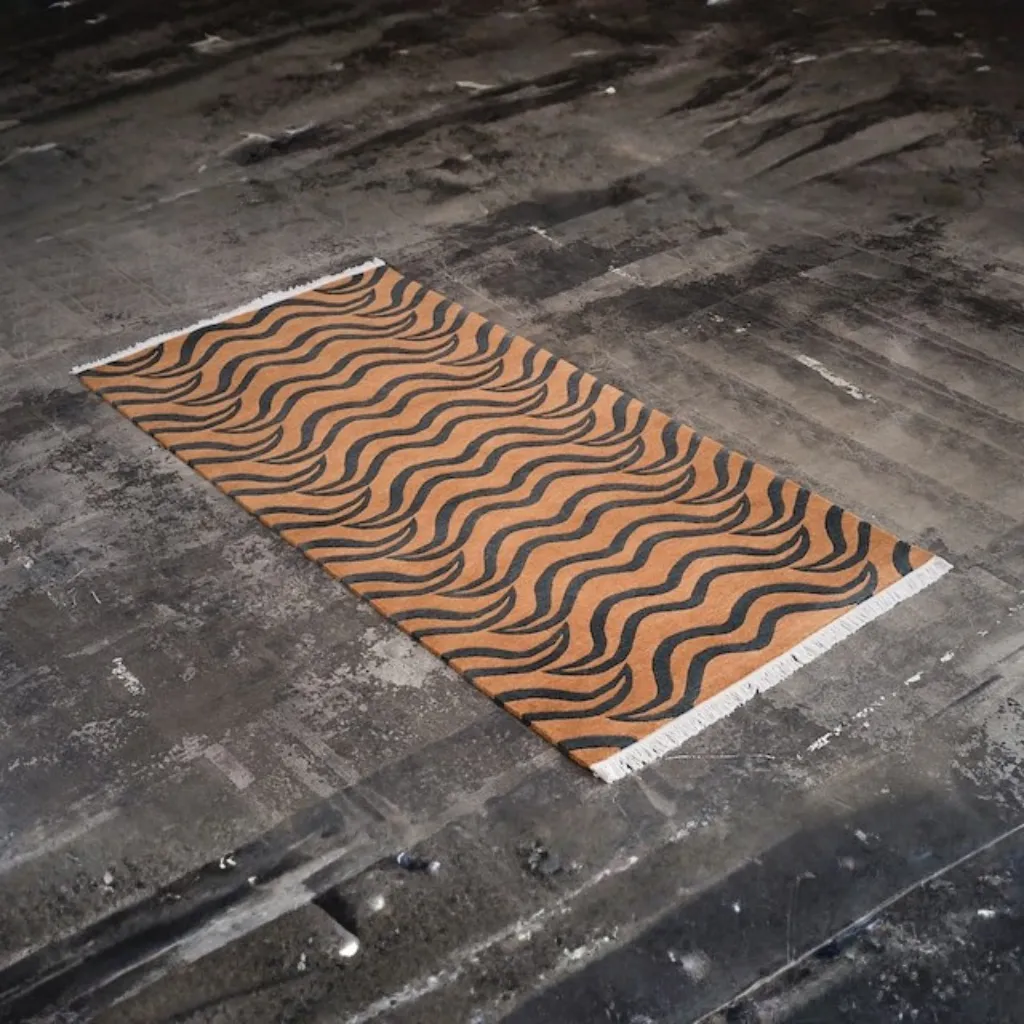 feral fur hand tufted wool brown tiger rug design Angled view of the Feral Fur rug, highlighting the dense hand-tufted wool texture and the raw, naturalistic black stripe pattern on a warm brown field.