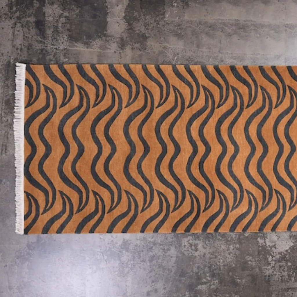 feral fur natural brown tiger skin shaped rug wood floor High angle view of the full Feral Fur rug placed on a rustic wooden floor, showcasing the traditional Tibetan tiger skin shape in an earthy palette of deep browns, beiges, and black.