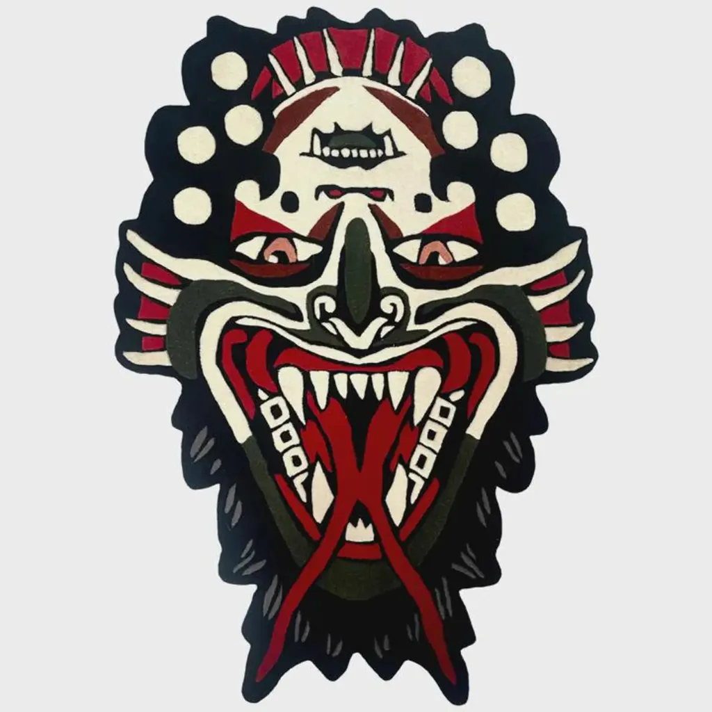 flip face traditional tattoo rug flat lay Top down view of the Flip Face rug featuring a reversible optical illusion design in a traditional tattoo style, depicting a demon mask with a red tongue and sharp teeth.