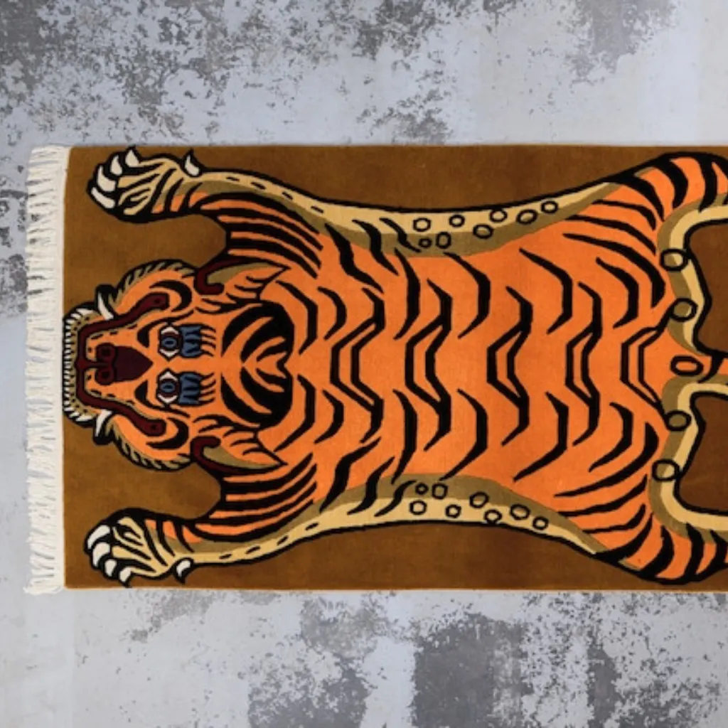 High angle view of the full Sunstripe Roar rug placed on a rustic wooden floor, showcasing the traditional Tibetan tiger skin shape in a vibrant mustard yellow and black colorway.