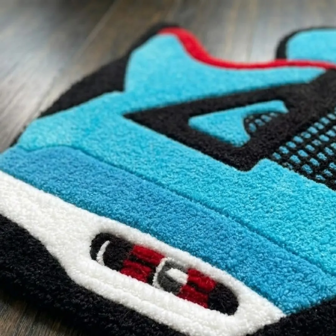 Close-up of the detailed tufted pile texture, air unit detail, and vibrant blue and black design on the Aqua Velocourt rug.