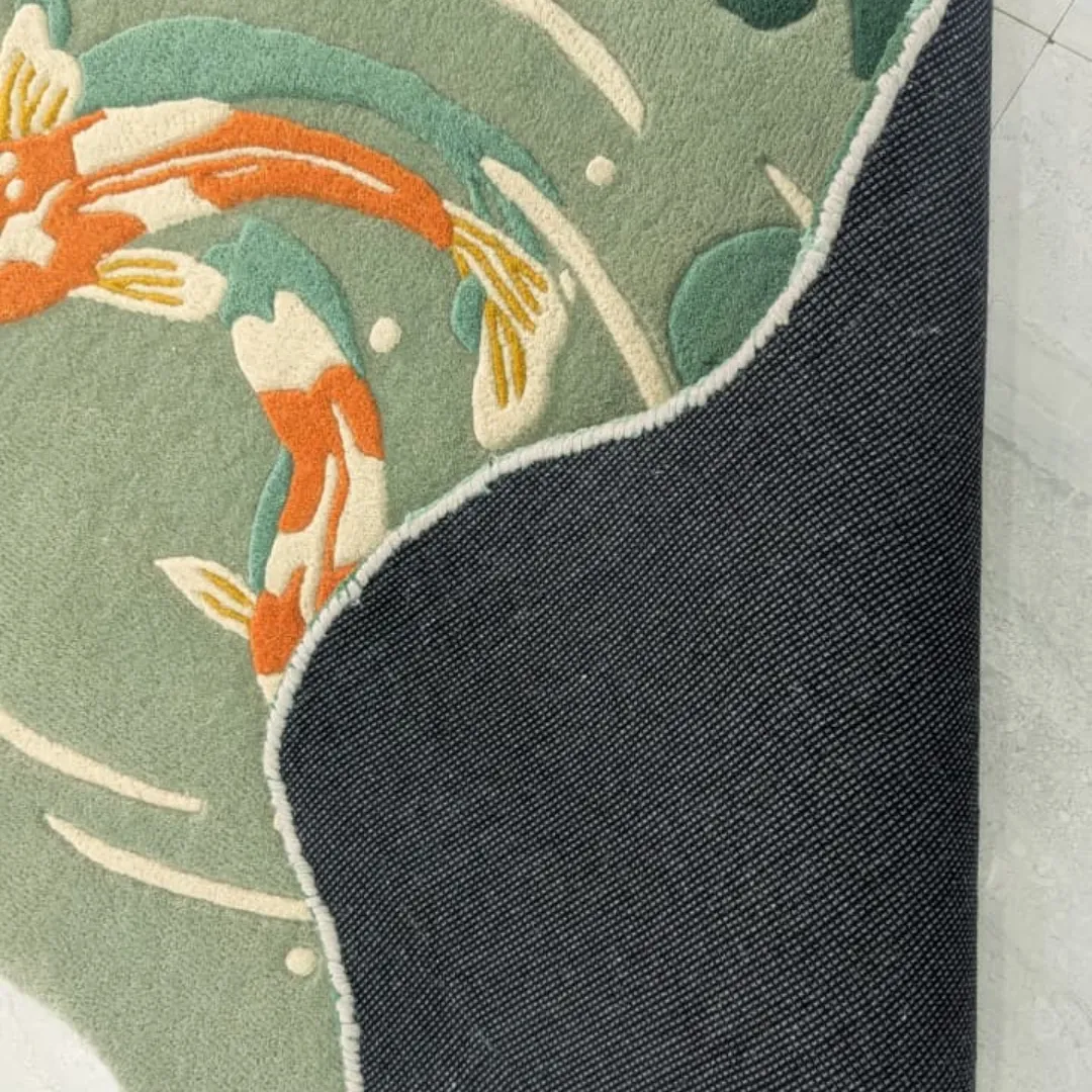 View of the underside of the Mizu Garden rug revealing the durable canvas backing and high-quality hand-finished edges next to the soft green wool pile.
