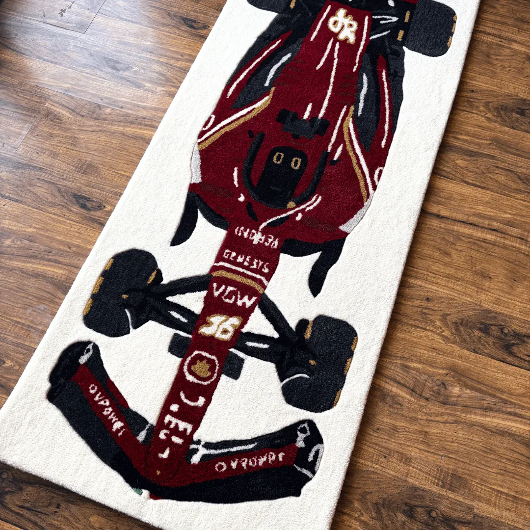 Angled view of the Scarlet Force rug, highlighting the rich maroon and red tones of the race car design and the soft hand-tufted wool texture.