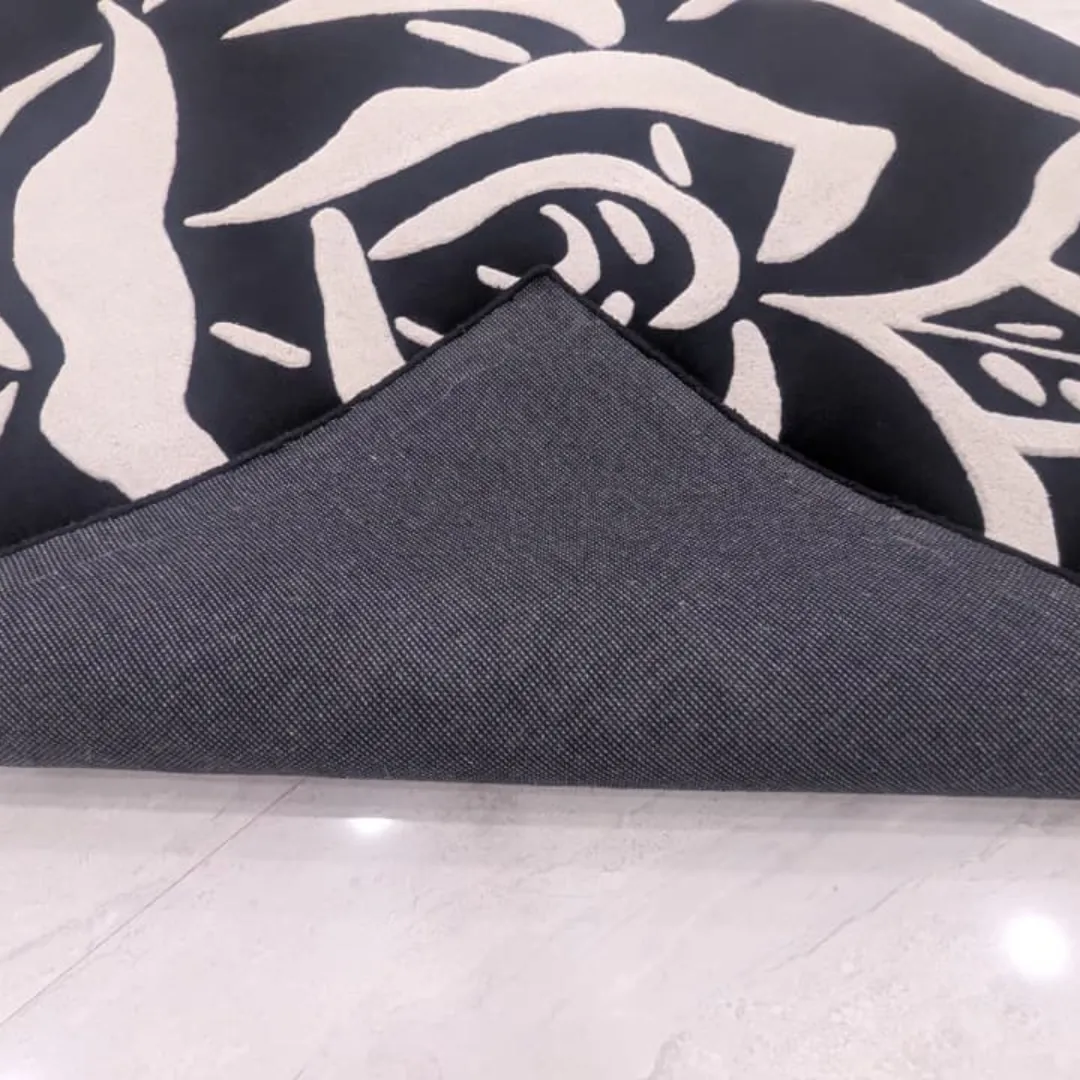 Close-up view of the underside of the Shadow Rose rug, revealing the durable grey canvas backing and high-quality edge binding construction.