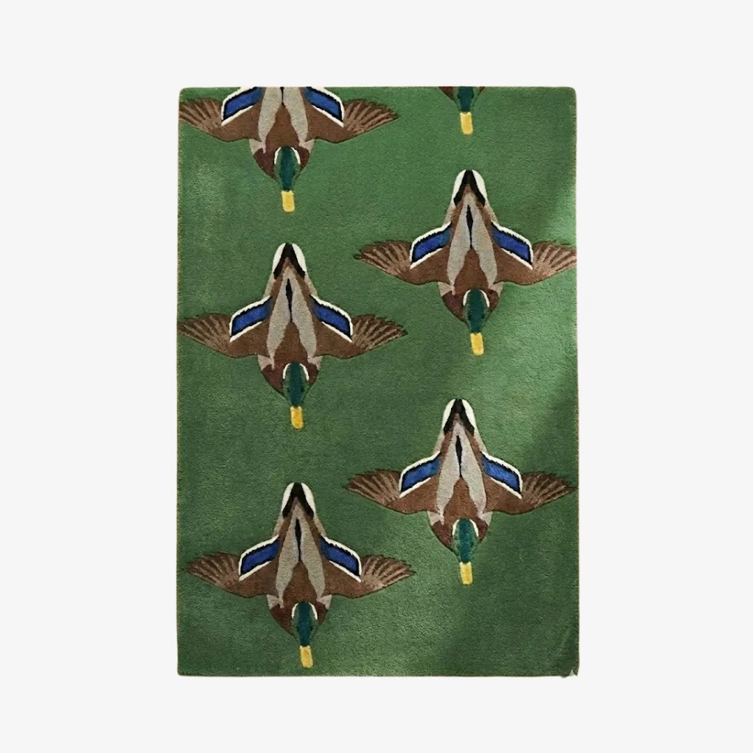 Top down view of the Verdant Flight rug showcasing the consistent pattern of mallards in flight against a deep verdant green backdrop.