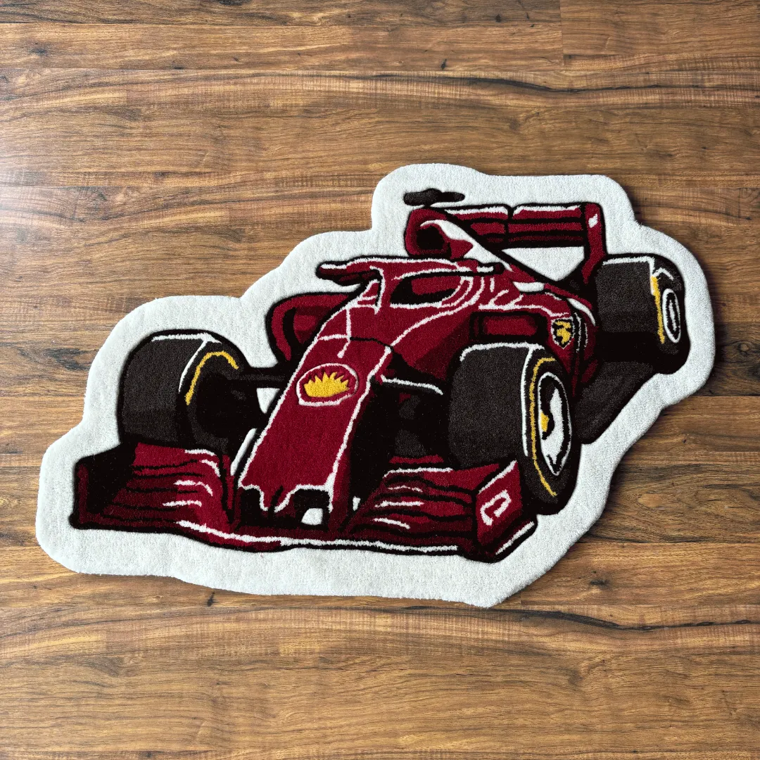 Top down view of the Victory Drive rug featuring a unique die-cut shape illustrating a red Formula 1 race car with black tires and white accents.