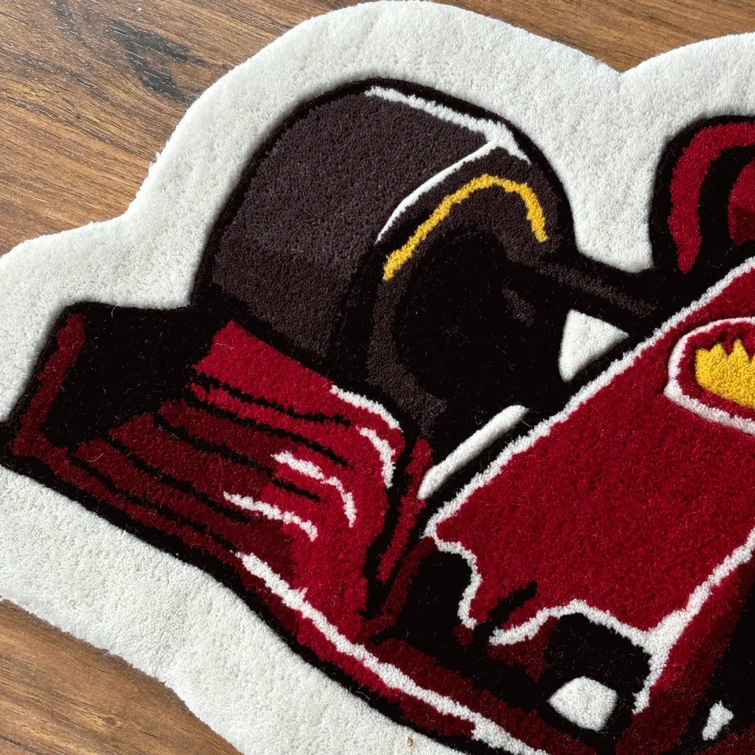 Detailed close-up of the Victory Drive rug highlighting the black tire and front wing assembly with white outlines.