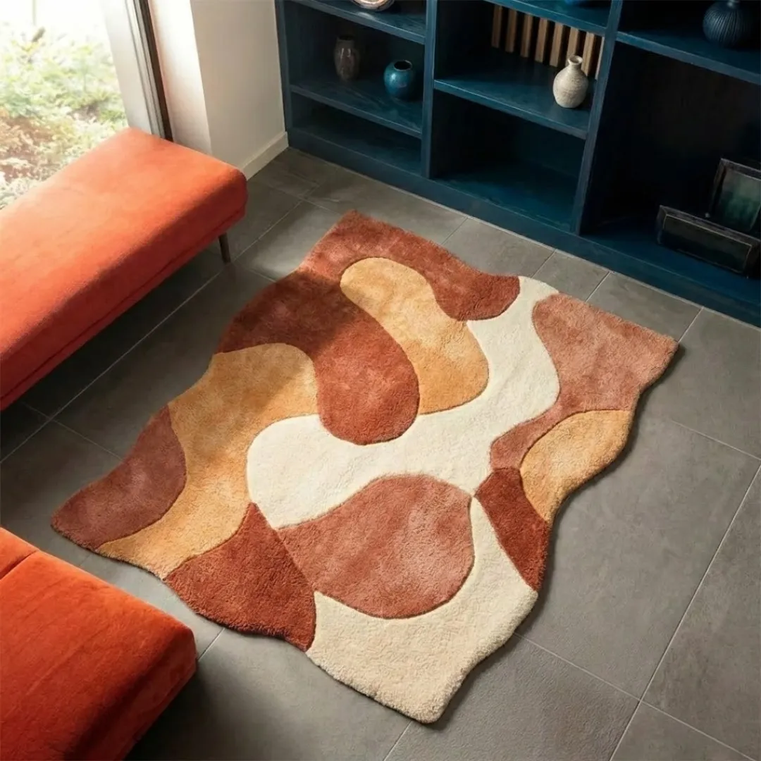 High-angle lifestyle view of the Aren Morph rug showcasing its dense, plush hand-tufted wool texture and the elegant, curved layout of its terracotta, tan, and cream fluid shapes in a sunlit modern interior.