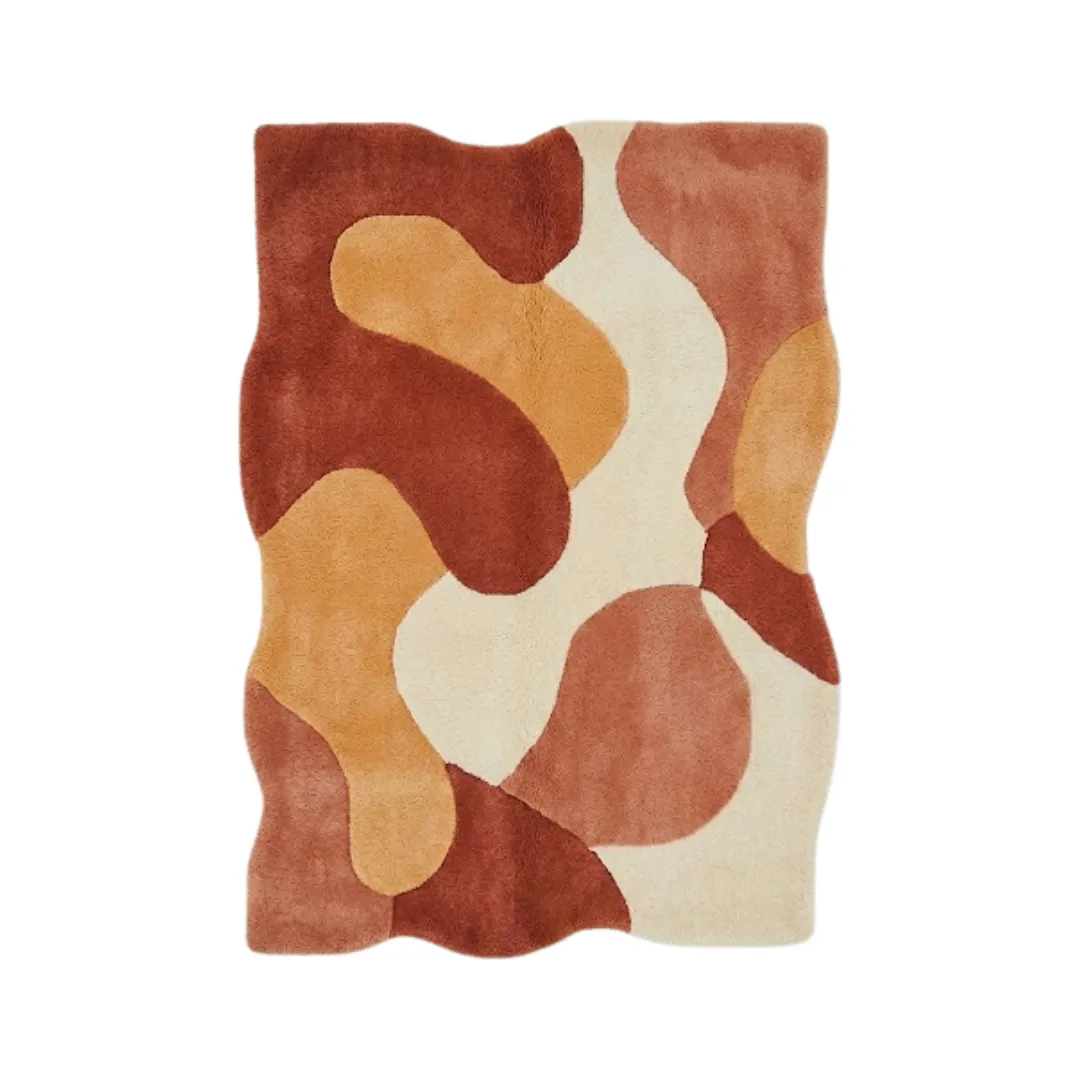 Top-down view of the Aren Morph rug featuring an organic, wavy irregular silhouette and a fluid abstract pattern in warm, earthy shades of terracotta, mustard, and cream.