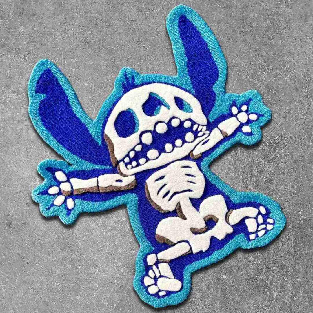 Top-down view of the shaped Azure Flux rug on a textured concrete surface, featuring a streetwear-inspired blue alien character with a detailed white skeleton and skull design.