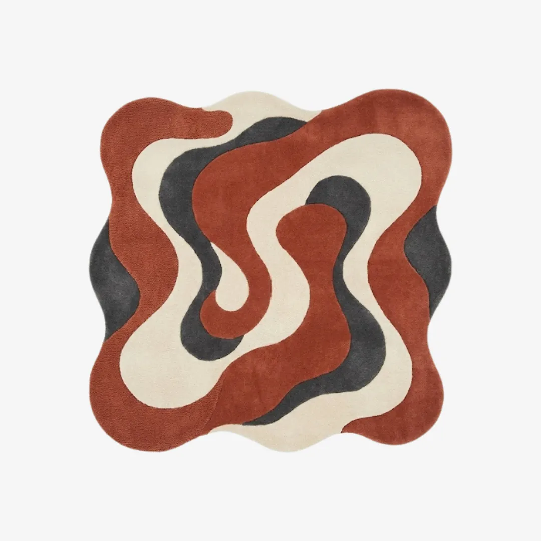 Top-down view of the Cavaro Flow rug featuring an organic, wavy irregular silhouette and a dynamic swirling pattern in dark terracotta, charcoal grey, and cream.