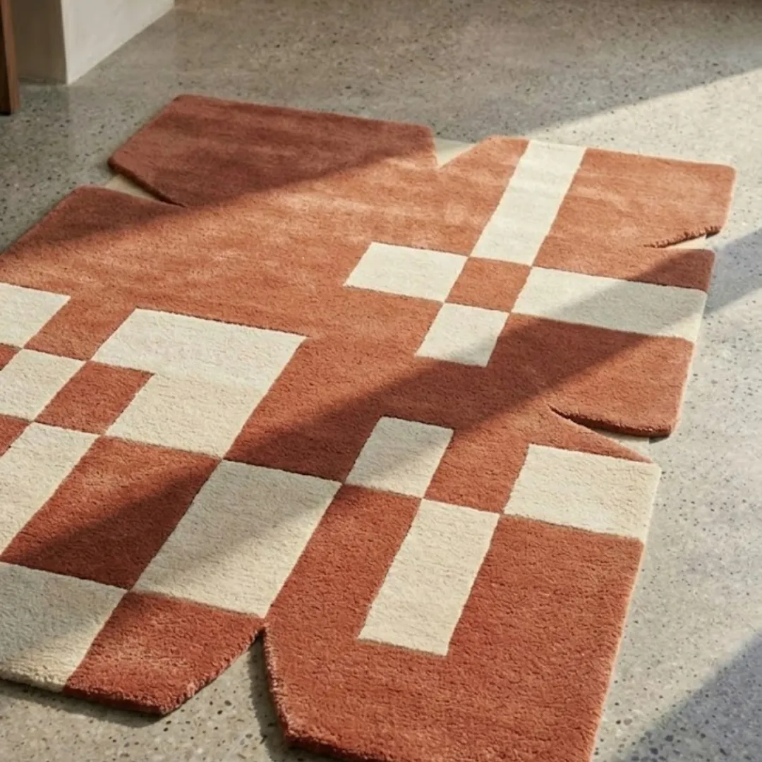 Close-up view of the Desert Codec rug, highlighting the dense, plush hand-tufted wool texture and the clean lines of the terracotta and ivory geometric design.