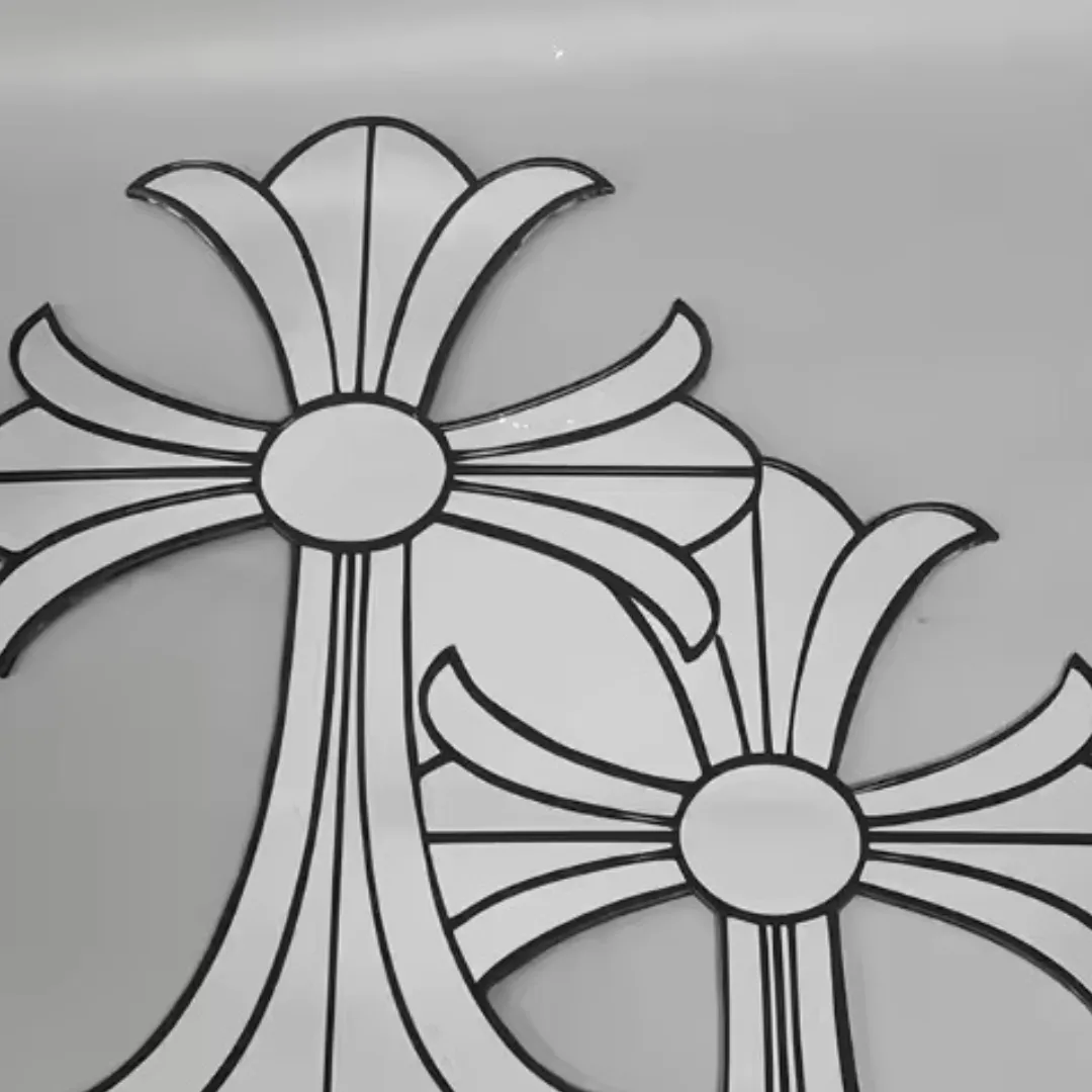 Close-up, slightly angled view of two gothic cross-shaped mirrors, highlighting the sharp points of the design and the bold black borders against a grey background.