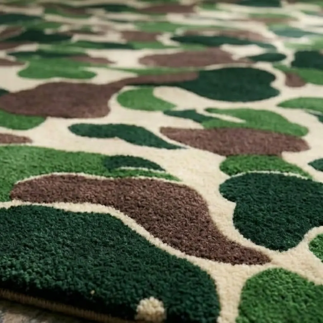 shadowfield camo terrain area rug texture close up A macro close-up of the shadowfield camo terrain rug, focusing on the dense, tufted wool pile and the intricate camouflage pattern in green, brown, and cream tones.