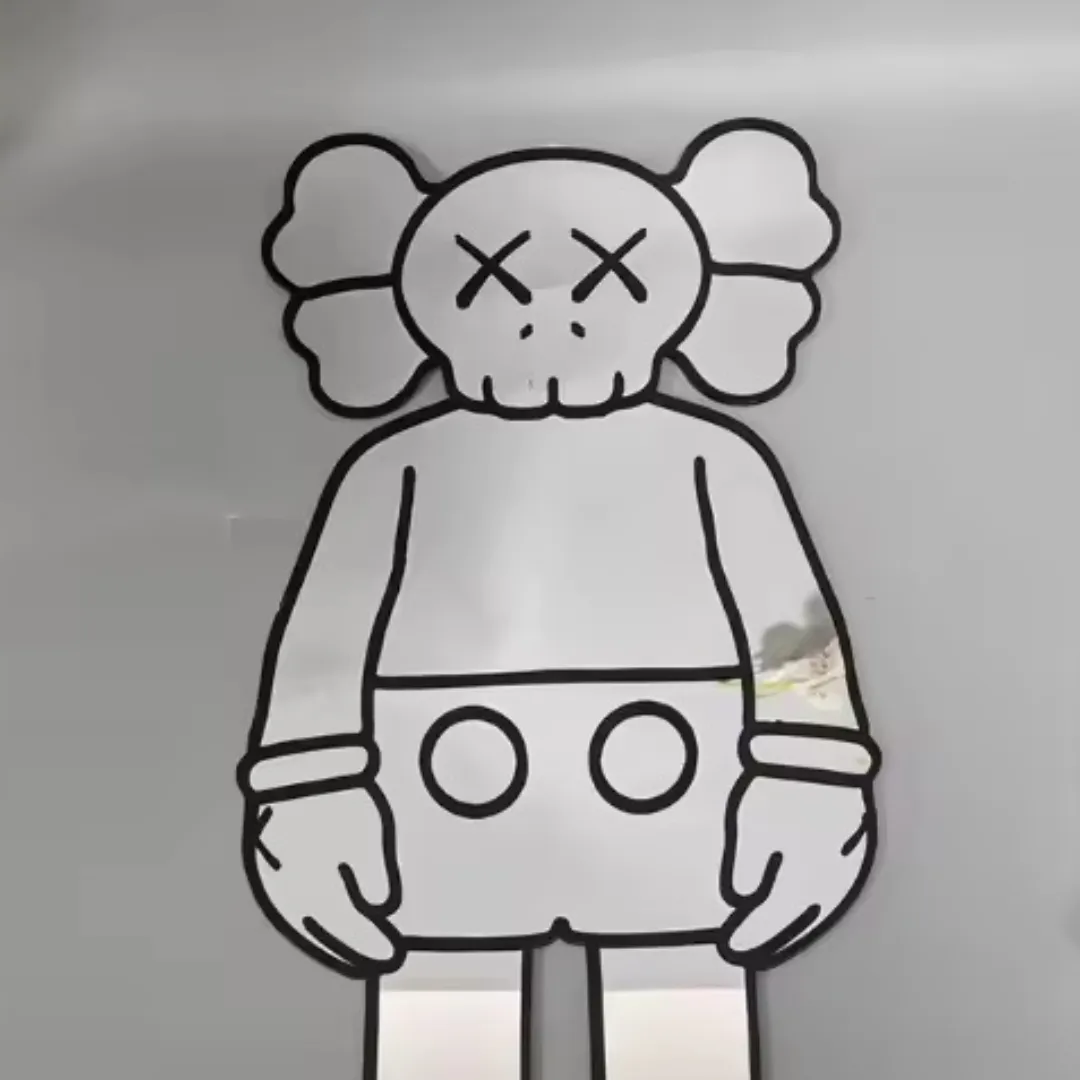 Close-up view of the Street Bear mirror lying flat, showcasing the bold black outlines of the character's face and reflecting a bright room environment.